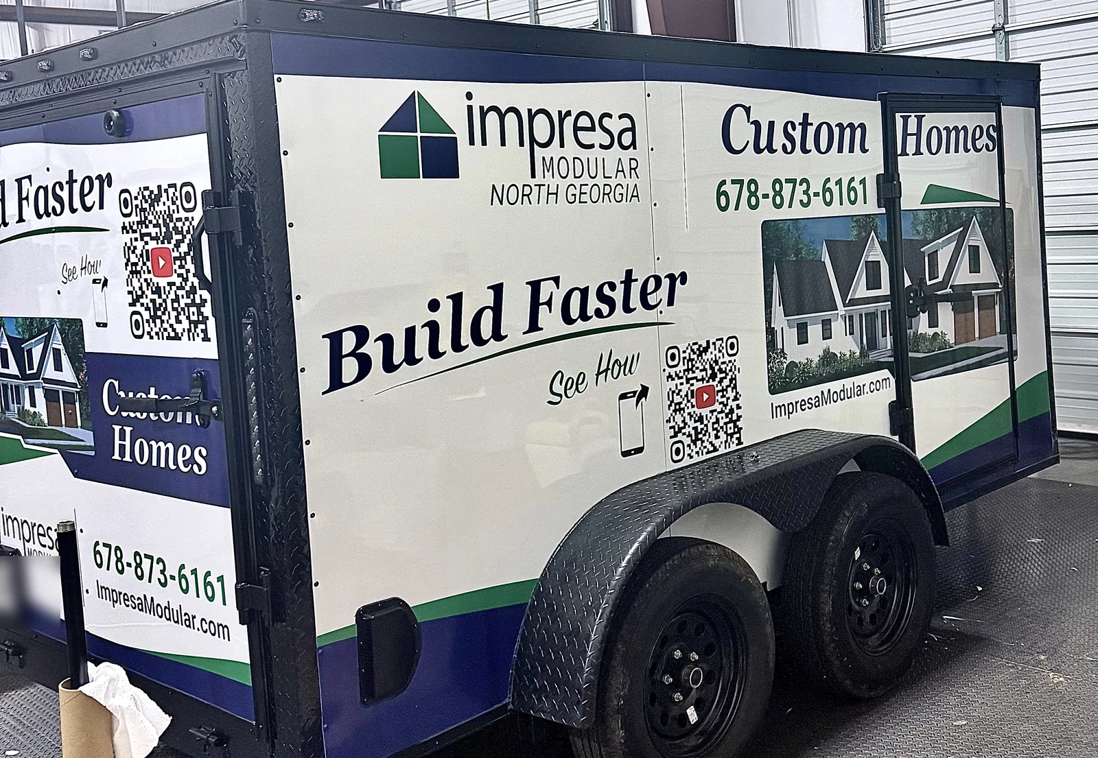 Side view of the Impresa Modular branded enclosed trailer wrapped by Vinyl Alchemy